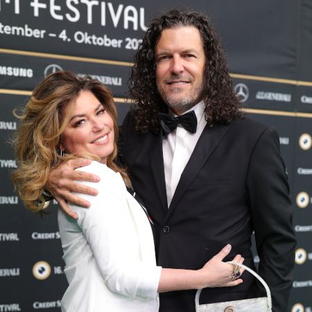 Shania and her husband holding eachother for a photo